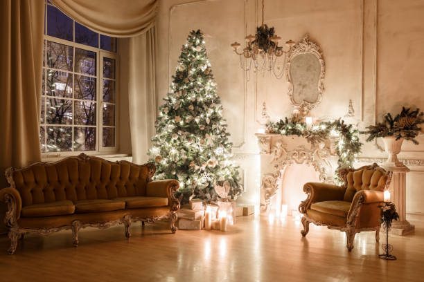 istock Christmas evening by candlelight. classic apartments with a white fireplace, decorated tree, sofa, large windows and chandelier. 893294036