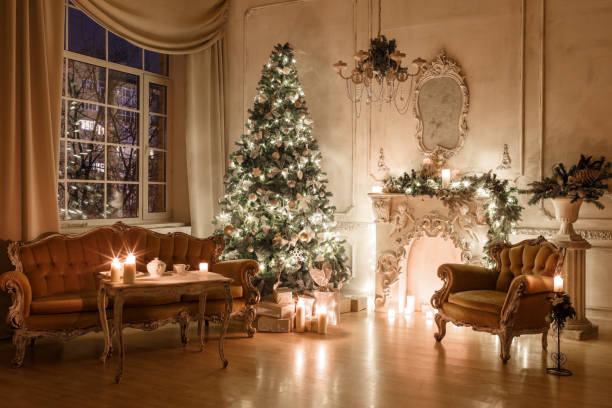 istock Christmas evening by candlelight. classic apartments with a white fireplace, decorated tree, sofa, large windows and chandelier. 893294078