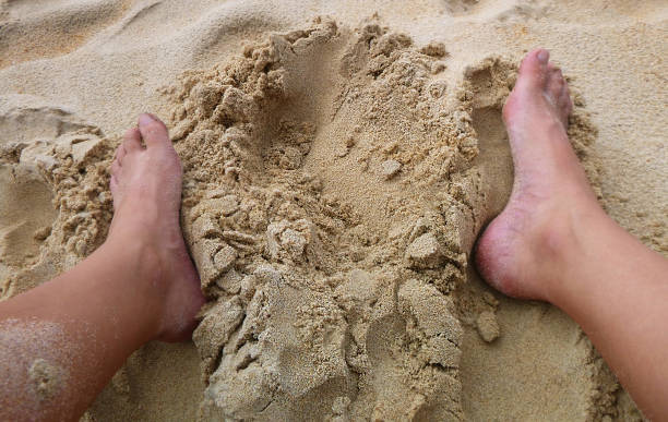 istock Two feet around hole in the sand 893297072