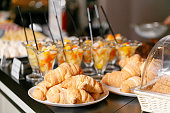 Fresh pastry, crispy morning croissants, hotel breakfast buffet. Dessert fruit cocktail in cups