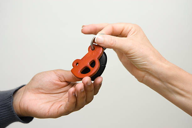Car key with remote control to lock or unlock the car and open the car trunk on yellow background