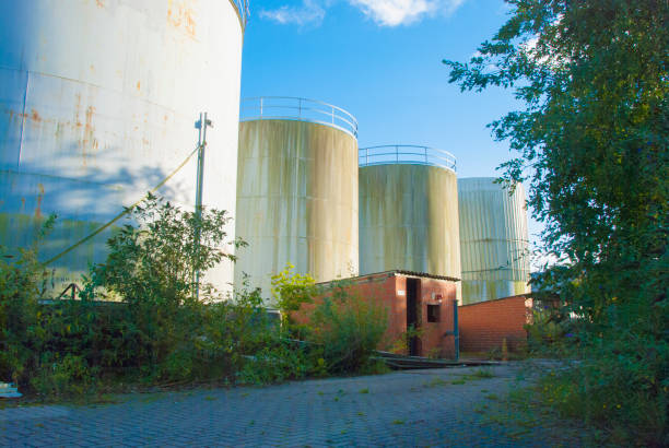 derelict industrial tanks overgrown with weeds and rusty