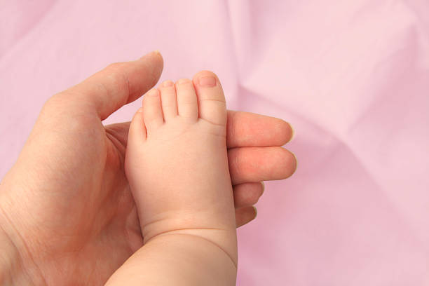 Baby Foot in Mothers Hand stock photo