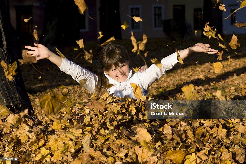 La ragazza su foglie d'autunno - Foto stock royalty-free di Adulto