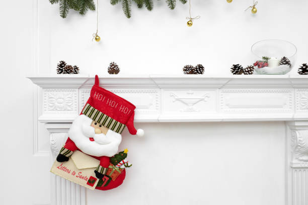 une image proche de joliment décorées de noël santa chaussettes avec ho ! ho ! ho ! mot, suspendu à une cheminée en attente pour cadeaux - chambranle photos et images de collection