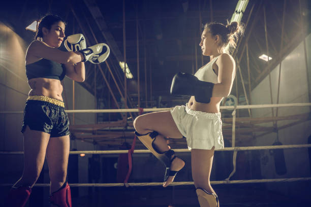 istock Determined female boxers fighting on a kickboxing match in a ring. 893339216