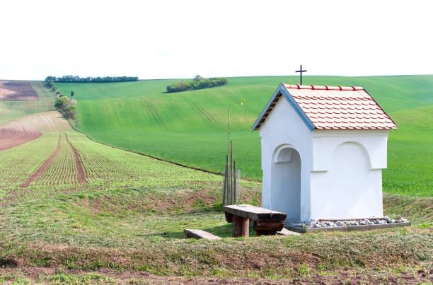 Spectacular rural landscape with small chapel in green wavy hills highlands in South Moravia, Czech Republic. Vibrant multicolored bright outdoors summertime horizontal image.