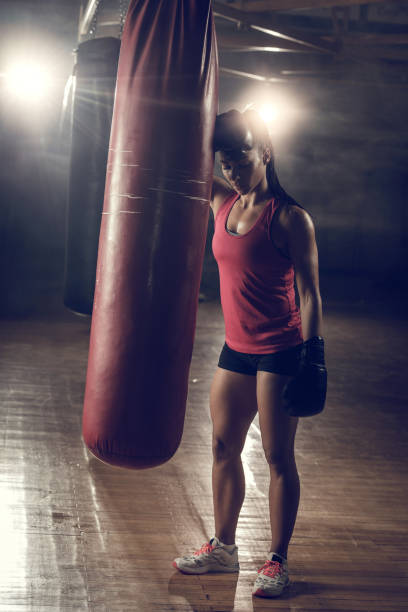 comprimento total da mulher cansada construção muscular após o treino de boxe em um ginásio. - sports training muscular build women body care - fotografias e filmes do acervo