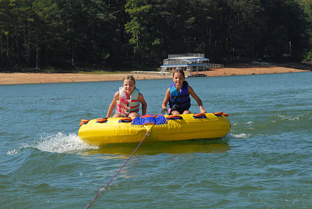 istock Two girls on tube behind boat 89334597