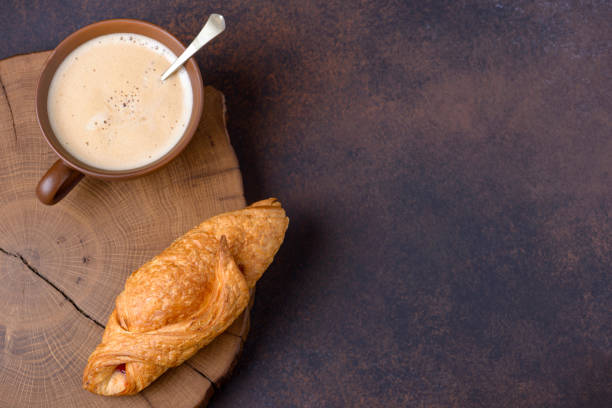 istock Tasty croissant and coffee cup 893359582