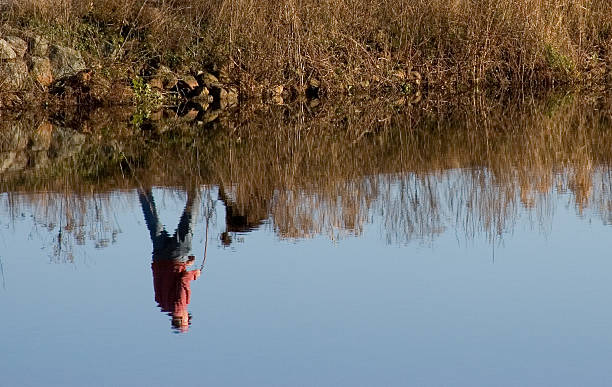istock Man and dog walking reflected in water 89336300