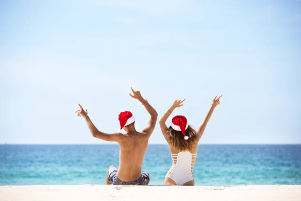 istock Happy couple in Santa's hats at tropical beach 893366614