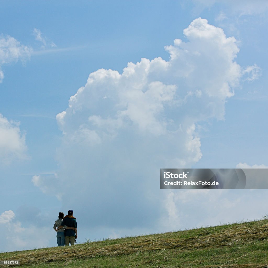 Loving couple on Защитная дамба глядя на величественный Облачный пейзаж - Стоковые фото Вид сзади роялти-фри