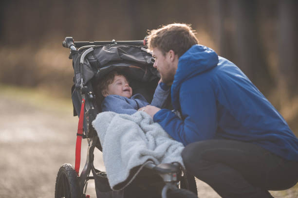istock Dad Taking His Son for a Walk in the Stroller 893385246