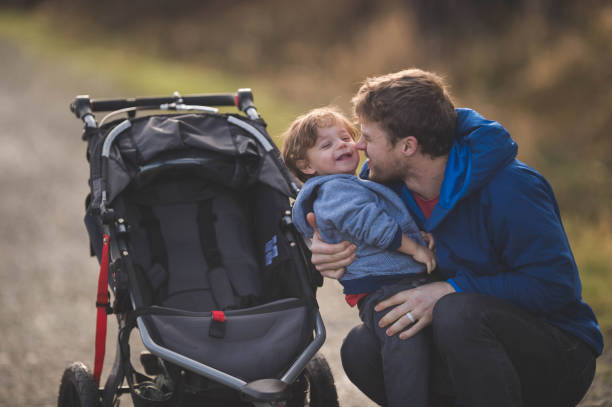 istock Dad Taking His Son for a Walk in the Stroller 893385250