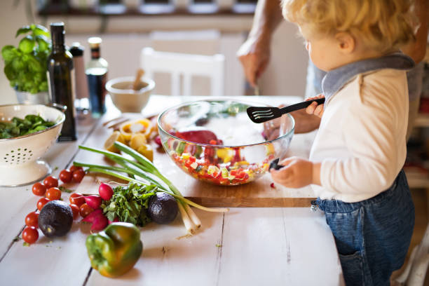 istock Young father with a toddler boy cooking. 893385762