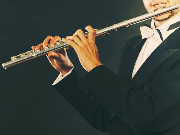 istock Elegantly dressed male musician playing flute 893404516