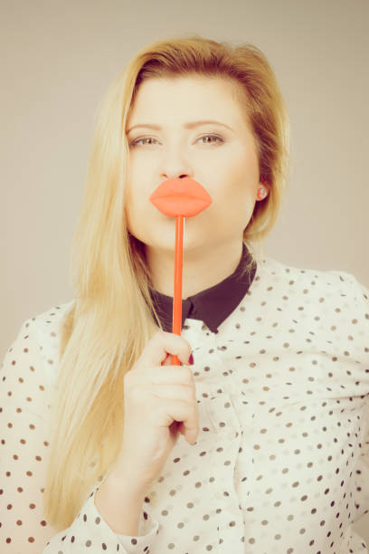 istock Happy woman holding fake lips on stick 893406846