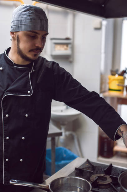 istock Male cook preparing meal on restaraunt kitchen 893412166