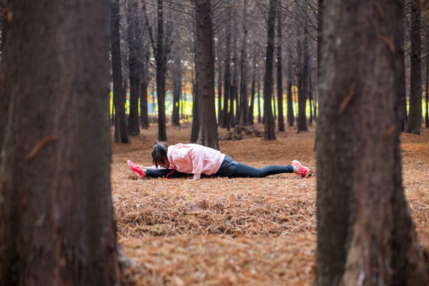 istock young female doing full spilt stretching on grass field 893412830