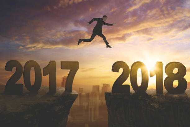 istock American businessman jumping above cliff 893419500