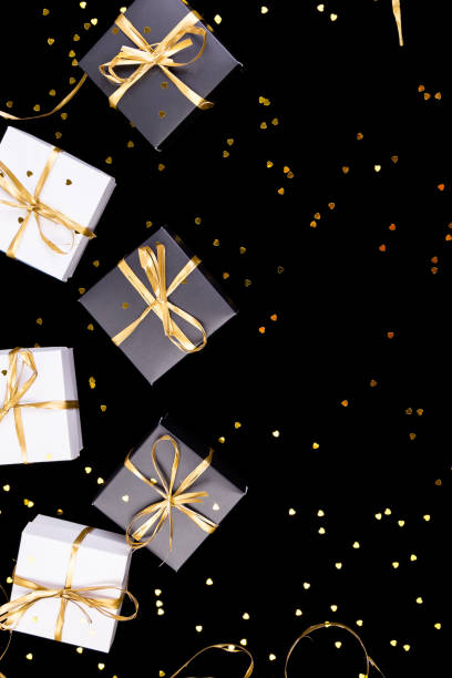 istock Black and white gift boxes with gold ribbon on shine background. Flat lay. Copy space. 893419672