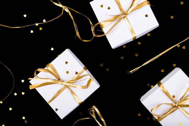 istock White gift boxes with gold ribbon on shine background. Flat lay 893419682