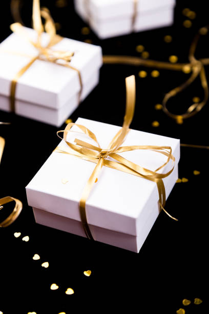 istock White gift boxes with gold ribbon on shine background. Close up. 893419706