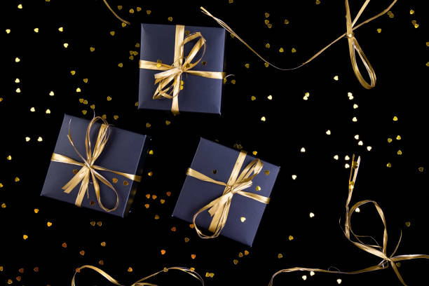 istock Black gift boxes with gold ribbon on shine background. Flat lay. 893419708
