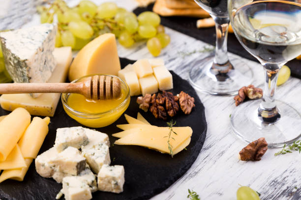 istock Cheese plate. Assortment of cheese with walnuts, bread an honey on stone slate plate. 893419778