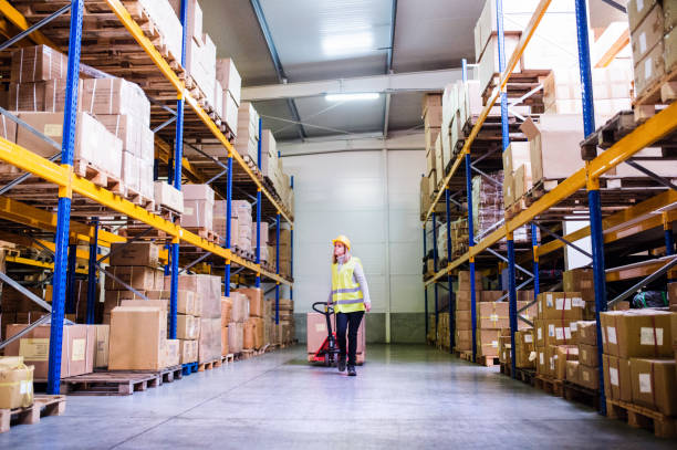 istock Woman warehouse worker with hand forklift truck. 893419986
