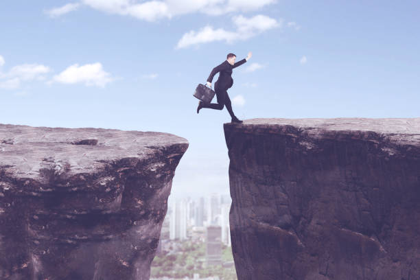 istock American manager jumping above gap cliff 893422950