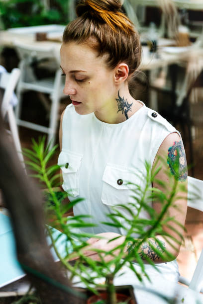 istock Woman with tattoo working in a garden 893429920