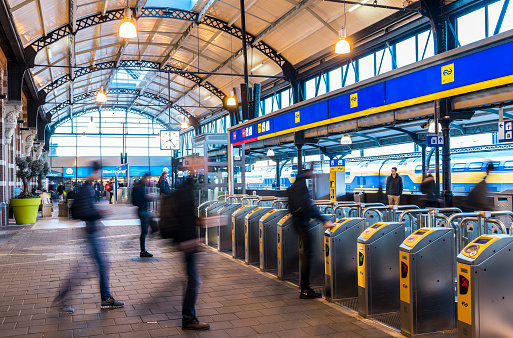 Nijmegen: OV-gates at railway central station Nijmegen with travellers and trains at the platform.