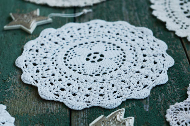 istock Handmade lace doily on green wooden background 893440194