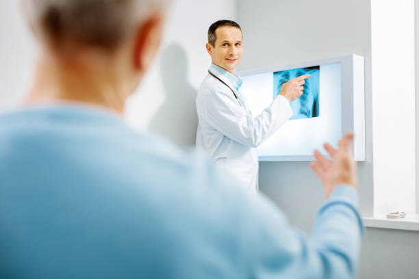 istock Nice delighted therapist pointing at the X ray photo 893443332