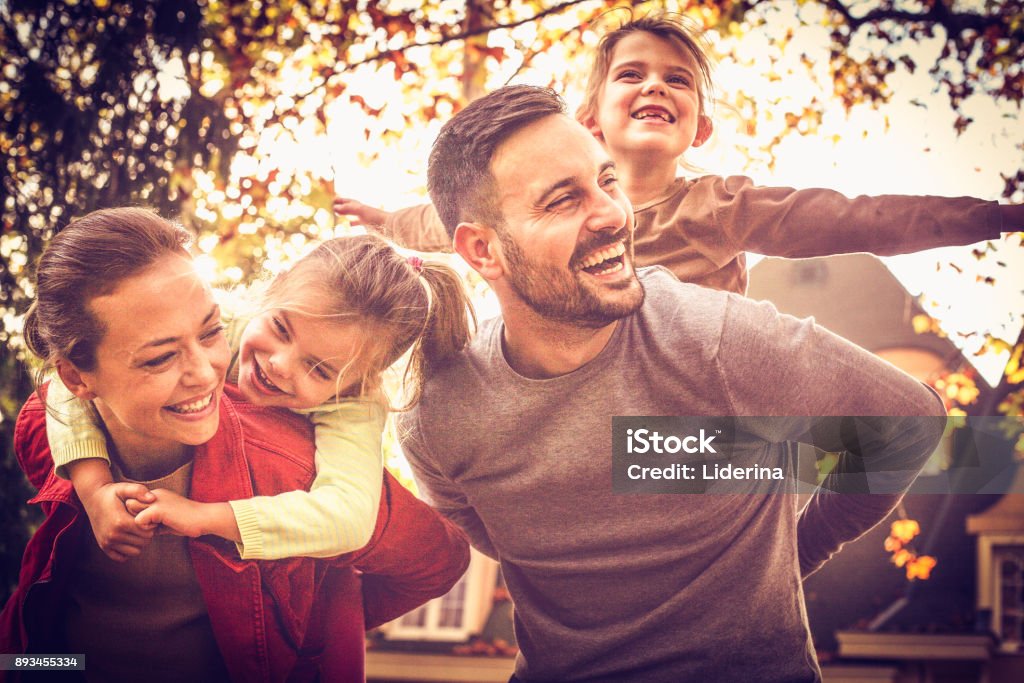 Eltern, die kleinen Mädchen auf Huckepack tragen. Zeit mit der Familie. - Lizenzfrei Familie Stock-Foto