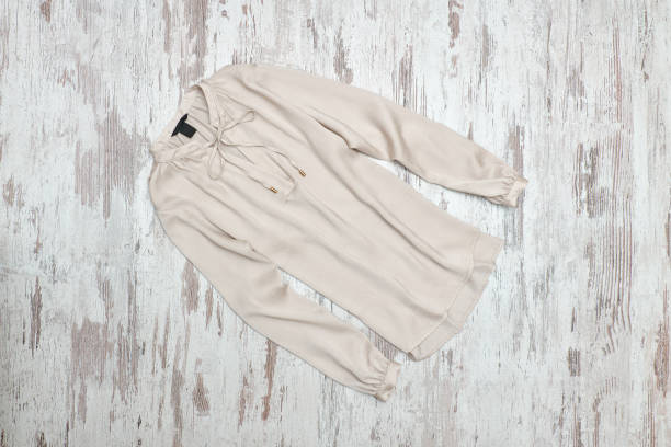 istock Beige blouse on a wooden background. Fashionable concept 893455708