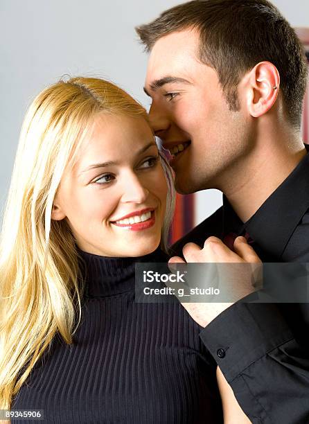 Two Young Happy Smiling Businesspeople Or Couple Telling A Secret Stock Photo - Download Image Now