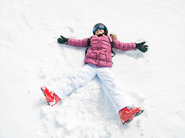 istock Little girl playing snow angel 893461312