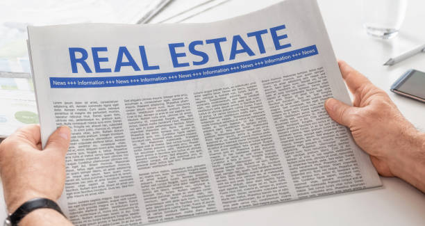 istock Man reading newspaper with the headline Real Estate 893469912