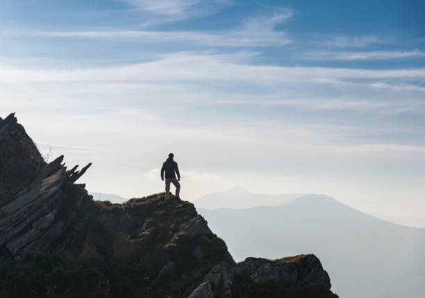 Man silhouette on top of mountain peak