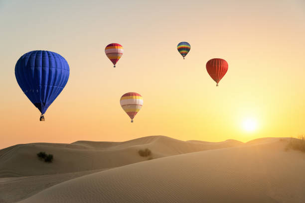 istock Hot air ballons flying over desert at sunset 893470410