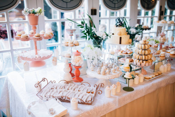 istock Candy bar and wedding cake with flowers. Table with sweets, buffet with cupcakes, candies, dessert. 893478732