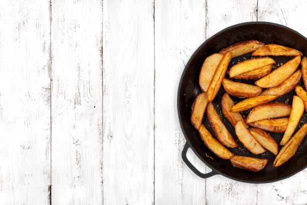 spicchi di patate su sfondo chiaro - roasted potatoes prepared potato herb food foto e immagini stock