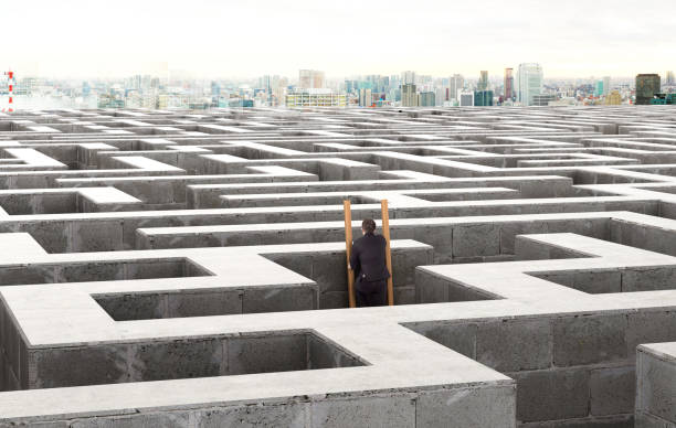 image of a businessman standing on the stairs in a labyrinth - maze solution business plan imagens e fotografias de stock