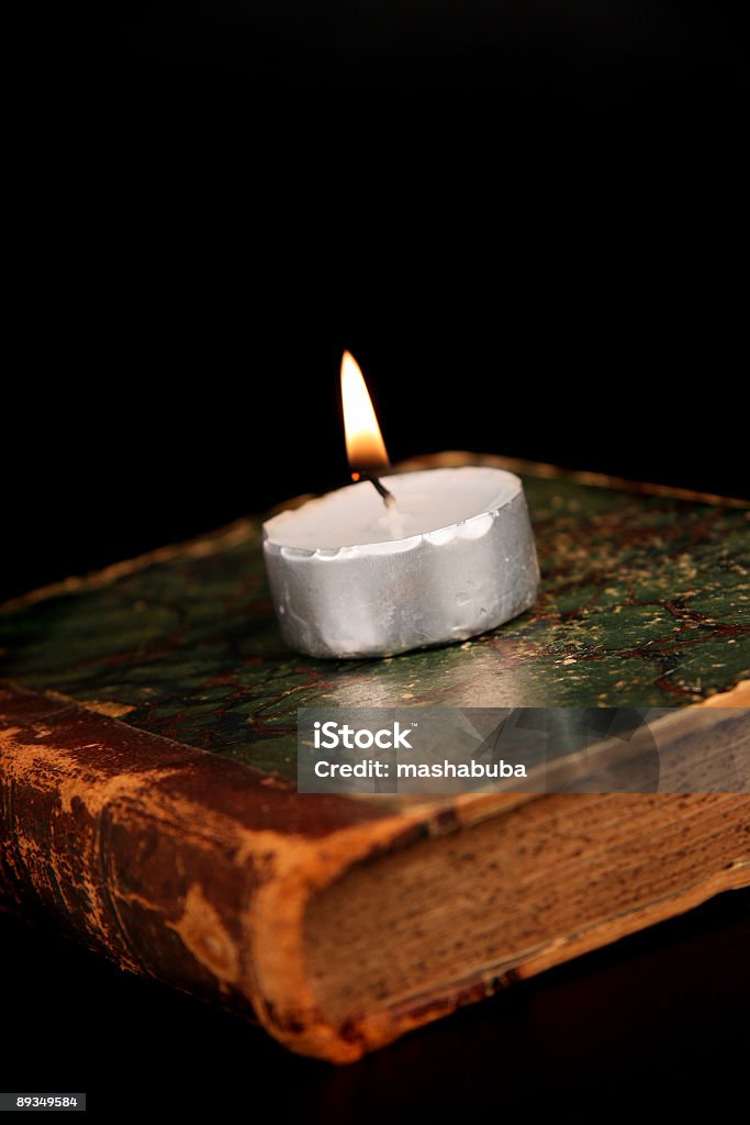 candle on the old book  Book Stock Photo