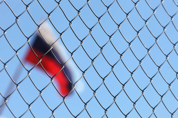 Russian flag after fence a fence of metal mesh behind which the Russian flag russia stock pictures, royalty-free photos & images