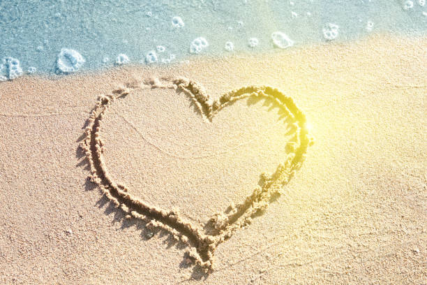 istock heart painted on the sand on the ocean 893501198
