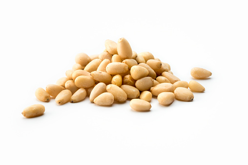 Nuts: high angle view Pile of white pine nuts on a white background